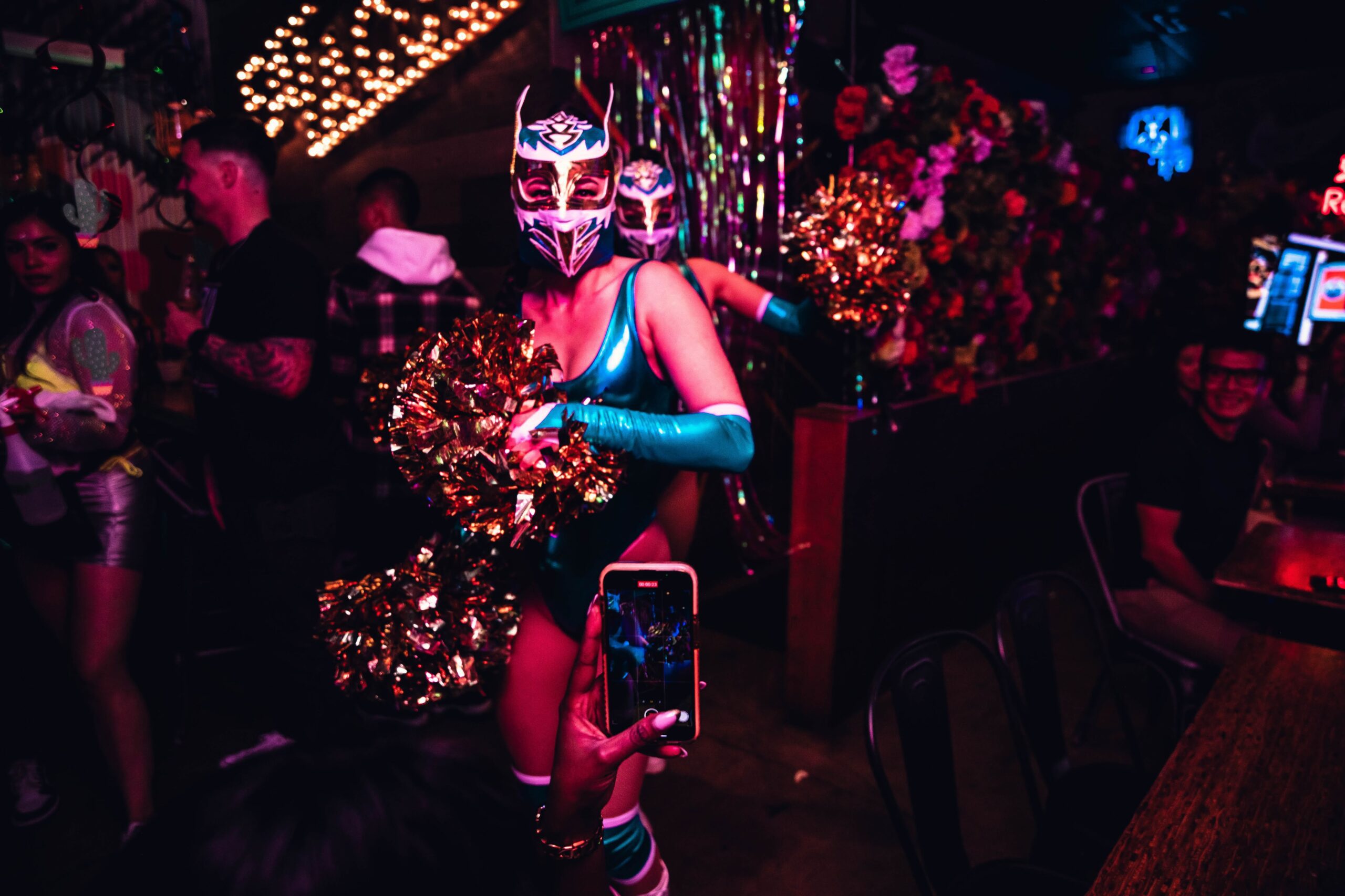 Two masked entertainers with pom-poms captivating guests at Pawn Shop YVR's Cinco de Mayo Vancouver party on Granville Street.