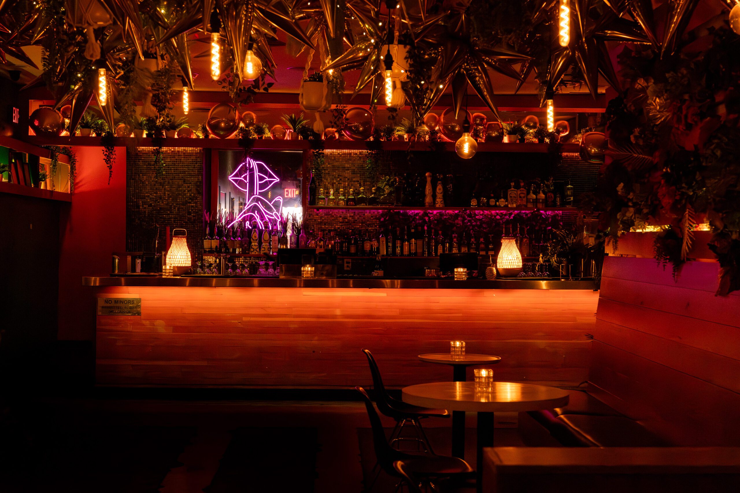 The Loft event space at Pawn Shop YVR, Vancouver. Dimly lit with candles, neon sign, and balloon decor create a unique vibe.