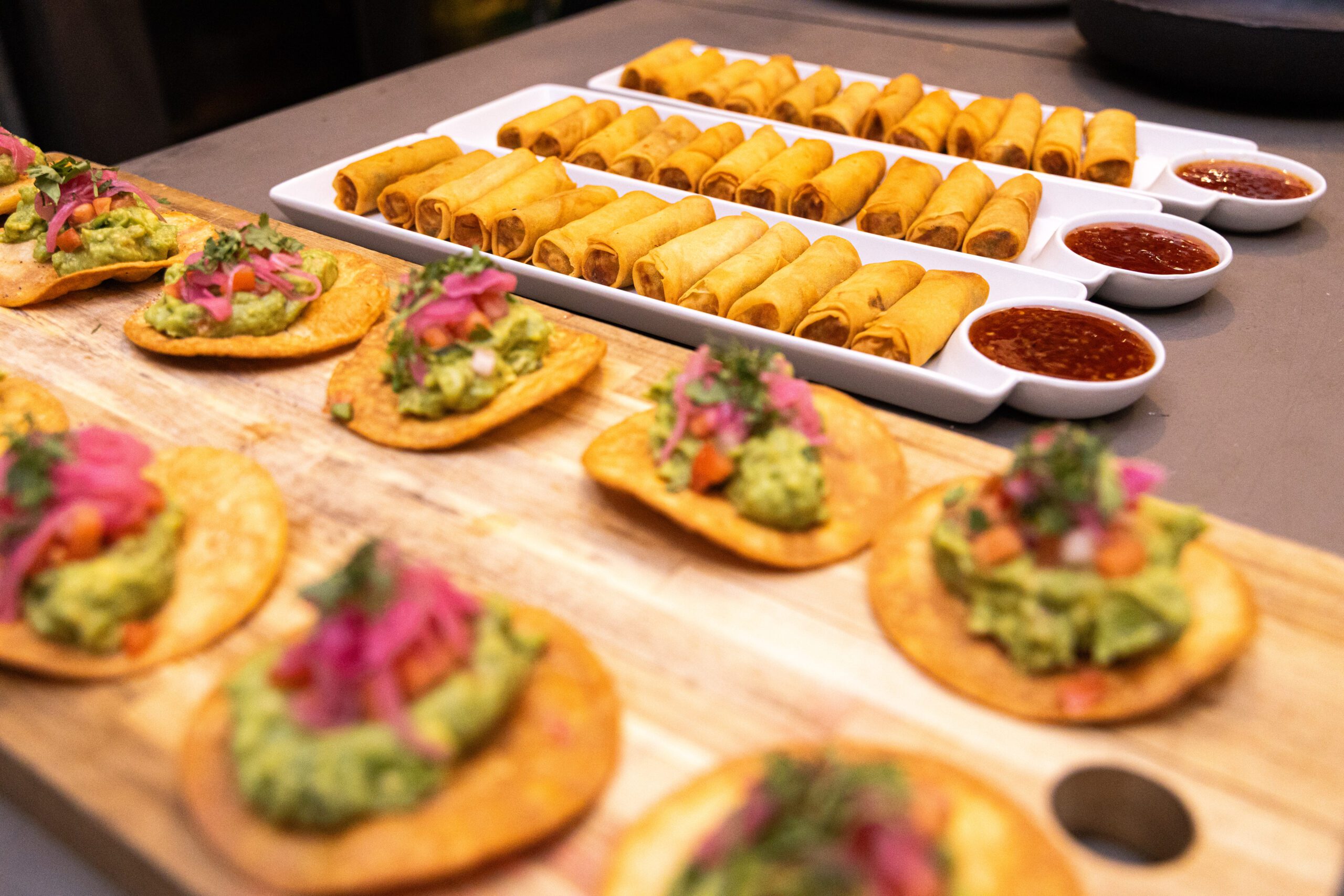 A vibrant tostada with fresh guacamole and pickled red onions from our catering menu.